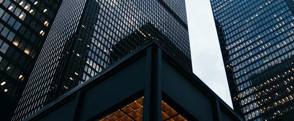 Office towers seen from below, against a pale sky.